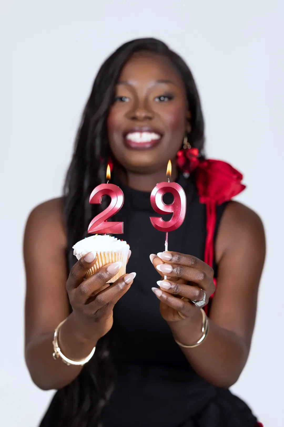 Woman celebrating her birthday holding a cupcake and number candles